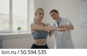 Doctor assisting patient with arm exercises in medical office. Стоковое AI-видео, аниматор Юрий Поздников / Фотобанк Лори