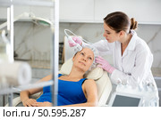 Professional beautician makes cryotherapy for rejuvenation woman face, anti aging procedure and shrink pores and repair damaged skin in salon. Стоковое фото, фотограф Яков Филимонов / Фотобанк Лори