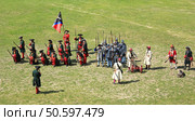 A group of soldiers, musketeers, midshipmen, artillerymen and grenadiers line up in a field, some of them holding weapons in their hands. Kolomna, Moscow region, Russia, 12.06.2015. Редакционное фото, фотограф Olga Golub / Фотобанк Лори
