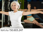 Gray-haired woman sitting on a Pilates platform. Стоковое фото, фотограф Яков Филимонов / Фотобанк Лори