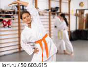 Young girl wearing kimono doing exercises in sports hall. Стоковое фото, фотограф Яков Филимонов / Фотобанк Лори