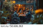 A group of four people, including a person in a wheelchair, enjoy time together at a table in an outdoor cafe. The cozy and warm atmosphere is emphasized by soft lighting, greenery and a relaxed atmosphere. The cafe is decorated with garlands and plants, creating a pleasant place for communication. The scene emphasizes inclusivity, friendship and the joy of life. Стоковое AI-изображение, AI-художник Анна Кривицкая / Фотобанк Лори