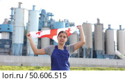 Calm young woman worker posing with Georgia flag in hands against background of factory. Стоковое видео, видеограф Яков Филимонов / Фотобанк Лори