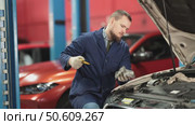 Male auto mechanic checking oil level in car engine in garage. Стоковое видео, видеограф Яков Филимонов / Фотобанк Лори