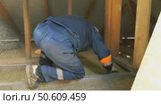 Insulation of a frame house with mineral wool. Cutting, fitting, laying insulation. Construction works. Стоковое видео, видеограф Константин Мерцалов / Фотобанк Лори