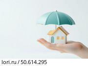 A protective hand gracefully covers a toy house under a large umbrella, symbolizing home insurance. This image highlights security and safety with an emphasis on safeguarding one's property. Стоковое AI-изображение, AI-художник Nart / Фотобанк Лори