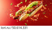 A vibrant explosion of flavor with deconstructed hot dog ingredients mid-air. The dynamic composition features a bright red backdrop, highlighting the ingredients' freshness and appeal. Стоковое AI-изображение, AI-художник Nart / Фотобанк Лори