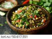 Sprouted moong bean salad with chopped tomatoes, onions, and cilantro in wooden bowl. Стоковое AI-изображение, AI-художник Иван Рябоконь / Фотобанк Лори
