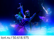 A girl dances in a show or circus in the blue rays of stage lighting. Стоковое фото, фотограф Лазаренко Светлана / Фотобанк Лори