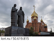Памятник Петру и Февронии Муромским, город Кемерово, Кемеровская область — Кузбасс, Россия. Скульптурная композиция «Святые благоверные князья Пётр и Феврония Муромские, покровители семьи и брака» расположена возле Знаменского собора. Супруги изображены в древнерусских одеждах, муж и жена держат в руках двух голубей. Эти птицы символизируют любовь, мир, кротость и чистоту. Скульптура служит напоминанием о важности семейных ценностей, любви и верности. Скульптор Константин Зинич. (2023 год). Редакционное фото, фотограф Андрей Степанов / Фотобанк Лори