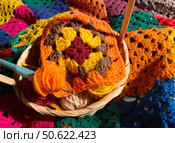 Crochet granny square, clews and hook on crochet blanket background photo. Стоковое фото, фотограф Елена / Фотобанк Лори