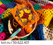 Crochet granny square, clews and hook on crochet blanket background photo. Стоковое фото, фотограф Елена / Фотобанк Лори