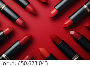 A frame with passion red lipsticks with empty vibrant red background in the middle. Beauty industry concept. Copy space. Advertisement for makeup artists. Стоковое AI-изображение, AI-художник Ирина Михайличенко / Фотобанк Лори