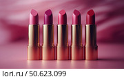 Row of passion pink lipsticks displayed against a vibrant pink background. Beauty industry and fashion concept. Copy space. Advertisement for makeup artists. Стоковое AI-изображение, AI-художник Ирина Михайличенко / Фотобанк Лори