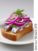 Pickled herring smorrebrod with red onions and dill on white bread. Стоковое AI-изображение, AI-художник Юрий Поздников / Фотобанк Лори