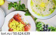 Eastern European breakfast spread featuring porridge, eggs, pancakes, and crepes neatly arranged on wooden table, highlighting traditional morning meal diversity. Стоковое видео, видеограф Данил Руденко / Фотобанк Лори