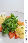 Gourmet breakfast plate displaying golden yolked poached eggs, creamy hollandaise, smoked salmon atop crisp arugula, garnished with delicate chives. Стоковое видео, видеограф Данил Руденко / Фотобанк Лори