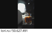 Coffee machine pouring espresso coffee into glass cup on dark background. Стоковое видео, видеограф Данил Руденко / Фотобанк Лори