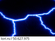 Vibrant electric blue lightning bolts illuminate a dark background, creating a striking contrast. The vivid energy and dynamic lines evoke a sense of power and intensity. Стоковое фото, фотограф Ольга Ильина / Фотобанк Лори