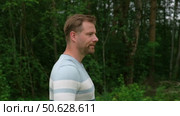 Handsome young man standing outdoors. Male thinking looking around feel happy, calm and serious. Green park background. Guy business employer, businessman manager inspired in nature. Diversity People. Стоковое видео, видеограф Марина Демидюк / Фотобанк Лори