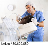 Professional aesthetician administering high frequency ultrasound facial procedure on man. Стоковое фото, фотограф Яков Филимонов / Фотобанк Лори