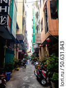 Narrow Alleyway With Motorbikes and Colorful Buildings in Ho Chi Minh City (2024 год). Редакционное фото, фотограф Aleksandr Golubev / Фотобанк Лори