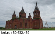 A large, abandoned red brick Orthodox church in a historic Russian village. wide shot. Стоковое видео, видеограф Strunov David / Фотобанк Лори