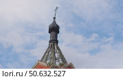A black Orthodox dome decorated with a tilted cross, towering atop a dilapidated bell tower built of brick and wood. Стоковое видео, видеограф Strunov David / Фотобанк Лори