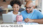 Young African American couple managing finances at home, with laptop, documents. Стоковое AI-видео, аниматор Екатерина Усенко / Фотобанк Лори