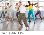 Asian guy practicing rhythmic aerobics during group workout. Стоковое фото, фотограф Яков Филимонов / Фотобанк Лори
