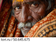 Indian sadhu wearing orange shawl and tilak on forehead. Стоковое AI-изображение, AI-художник Иван Рябоконь / Фотобанк Лори