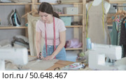 Woman seamstress cutting fabric in sewing workshop. Стоковое видео, видеограф Яков Филимонов / Фотобанк Лори