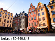 Colorful Buildings and Active Square at Stortorget in Stockholm, Sweden (2024 год). Редакционное фото, фотограф Aleksandr Golubev / Фотобанк Лори