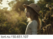 Little girl wearing pith helmet exploring nature at golden hour. Стоковое AI-изображение, AI-художник Иван Рябоконь / Фотобанк Лори