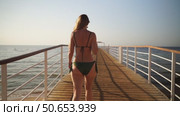 A woman goes swimming on a bridge in the sea. Стоковое видео, видеограф Igor Skripachev / Фотобанк Лори