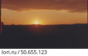 Vibrant sunset casting orange red hues across six landscape silhouettes, revealing urban structures and natural scenes against dimming evening sky, 8 mm film. Стоковое видео, видеограф Данил Руденко / Фотобанк Лори