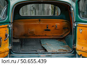 Empty trunk of an old abandoned rusty car showing signs of age and neglect. Стоковое AI-изображение, AI-художник Иван Рябоконь / Фотобанк Лори