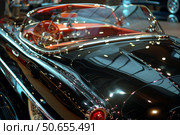 Shiny black convertible classic car parked in showroom. Стоковое AI-изображение, AI-художник Иван Рябоконь / Фотобанк Лори