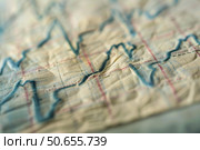Close up of wrinkled graph showing market volatility in finance. Стоковое AI-изображение, AI-художник Иван Рябоконь / Фотобанк Лори