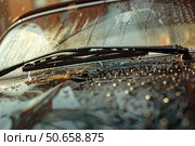 Windshield wipers cleaning water drops from car windscreen during rain. Стоковое AI-изображение, AI-художник Иван Рябоконь / Фотобанк Лори