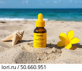 A bottle of Manbauu sunscreen sits on the sand next to a yellow flower. Стоковое AI-изображение, AI-художник Ярославский Максим / Фотобанк Лори