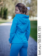 Smiling girl in blue tracksuit on street looking at camera. Стоковое фото, фотограф Роготнева Виктория / Фотобанк Лори