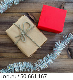 Christmas square background. Christmas gifts and tinsel on a wooden background. Стоковое фото, фотограф Юлия Николаева / Фотобанк Лори