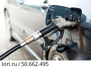 Gas station. Refueling a car with gasoline. Fuel dispenser in the car's fuel tank at a gas station. Rising fuel prices worldwide. Стоковое фото, фотограф Photojuli / Фотобанк Лори