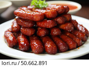 Delicious glazed cocktail sausages piled high on white plate. Стоковое AI-изображение, AI-художник Иван Рябоконь / Фотобанк Лори