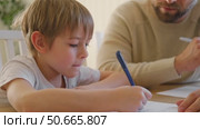 Dad teaches his son writing and counting. Kids primary education. Children learn, study in home school. Daddy male helping teaching little child boy support studying, learning homework. Knowledge day. Стоковое видео, видеограф Марина Демидюк / Фотобанк Лори