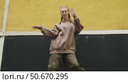 Gen z young woman dancing in front of city wall. Стоковое видео, видеограф Маргарита Кирьякова / Фотобанк Лори