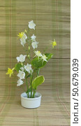 Vertical video of beautiful flower arrangement of yellow columbine, white bellflowers and green hosta leaves on kenzan holder on straw mat. Floral design as hobby and pleasure. Стоковое видео, видеограф Виктория Катьянова / Фотобанк Лори