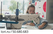 spool of thread, employed in process of sewing denim garments in a tailor's studio, while sewing machine is in use. Стоковое видео, видеограф Strunov David / Фотобанк Лори