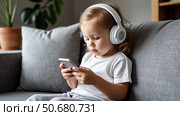 Cute kid girl in watching smartphone. Стоковое AI-изображение, AI-художник Ирина Гильмуллина / Фотобанк Лори